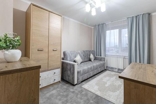 a living room with a couch and a large window at Просторная квартира рядом с набережной in Pavlodar