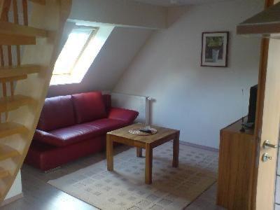 ein Wohnzimmer mit einem roten Sofa und einem Tisch in der Unterkunft Studio für 2 Personen ca 39 qm in Dassow-Wieschendorf, Ostseeküste Deutschland Landkreis Nordwestmecklenburg in Dassow