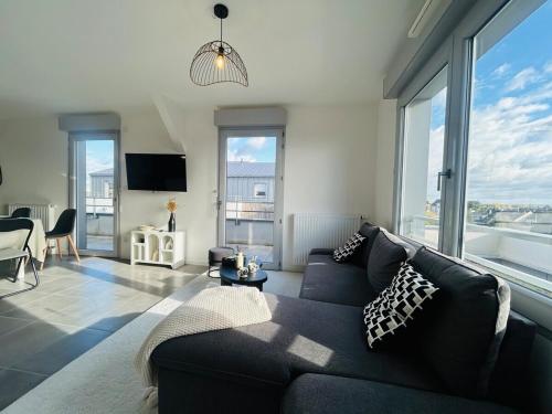 a living room with a couch and a large window at Casa Orgemont in Les Ponts-de-Cé