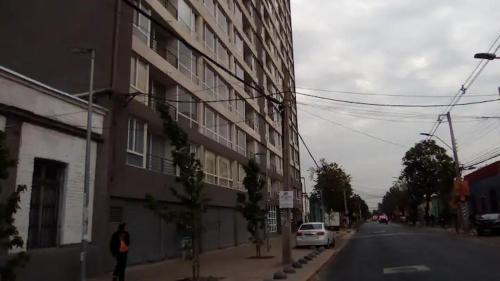 une personne marchant dans une rue à côté d'un bâtiment dans l'établissement Depto Edificio Vida Urbana, à Santiago