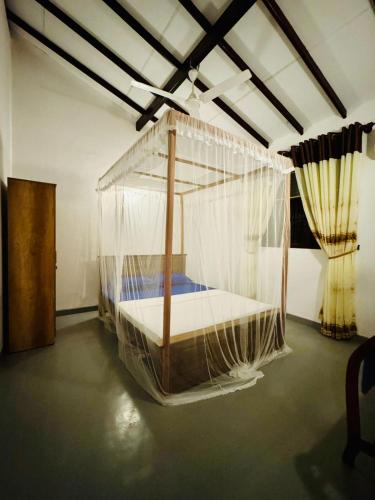 a bedroom with a bed covered in mosquito nets at Villa Happy Nest in Unawatuna