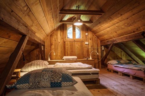 a bedroom with two beds in a wooden cabin at Gozdna koča Studeno in Kočevje