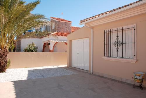 ein Haus mit einer weißen Tür und einem Zaun in der Unterkunft Ferienhaus mit Privatpool für 8 Personen ca 146 m in Estrella de Mar, Murcia Costa Calida in Los Urrutias