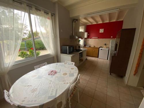 une cuisine avec une table blanche et une table et une cuisine dans l'établissement Gîte de Castellasses, à Castelmayran