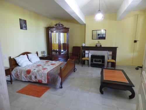 - une chambre avec un lit, un bureau et une cheminée dans l'établissement Gîte de Castellasses, à Castelmayran