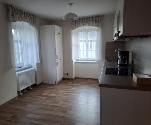a kitchen with a counter top and two windows at Erbgericht Putzkau in Putzkau