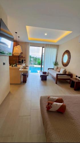 a large living room with a couch and a kitchen at Casa Makräm in Tulum
