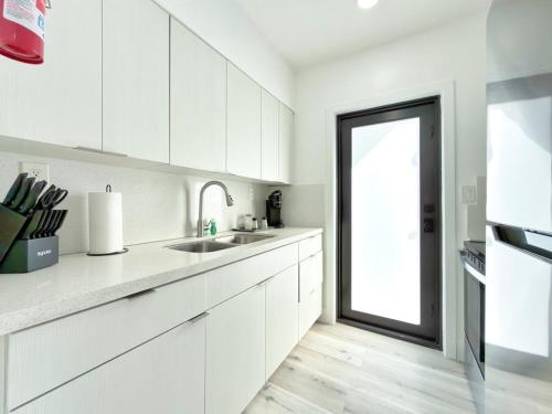 a white kitchen with a sink and a window at Miami Lux Retreat - Free Parking - Near Brickell in Miami