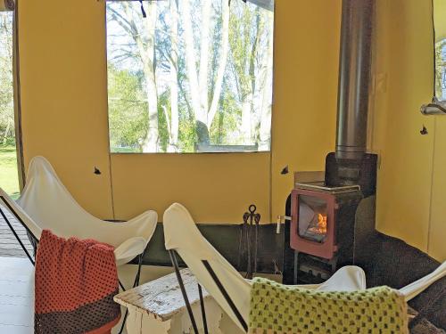 a room with chairs and a wood stove at The Apple Bobber - Ukc7130 in Cratfield