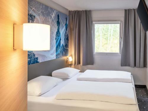 - 2 lits blancs dans une chambre avec fenêtre dans l'établissement B&B HOTEL Koblenz-Nord, à Mülheim-Kärlich