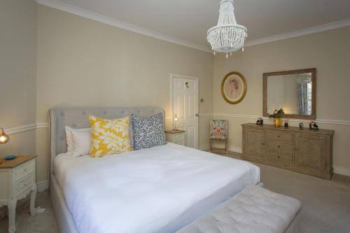 a bedroom with a large white bed and a mirror at Georgian Garden Apartment - Central Bath in Bath