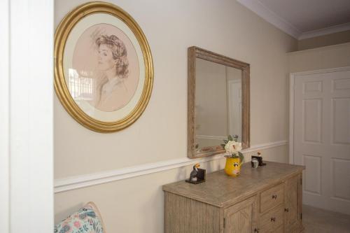 a mirror on a wall above a dresser in a room at Georgian Garden Apartment - Central Bath in Bath