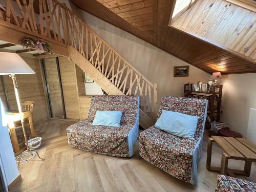 - deux chaises dans un salon avec un escalier dans l'établissement Triplex chaleureux 6 pax avec wifi et parking, Chantemerle, Serre-Chevalier - FR-1-330E-17, à Serre Chevalier