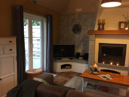 ein Wohnzimmer mit Couch und Kamin in der Unterkunft Ferienhaus für 5 Personen ca 100 m in De Panne, Flandern Plopsaland und Umgebung in De Panne