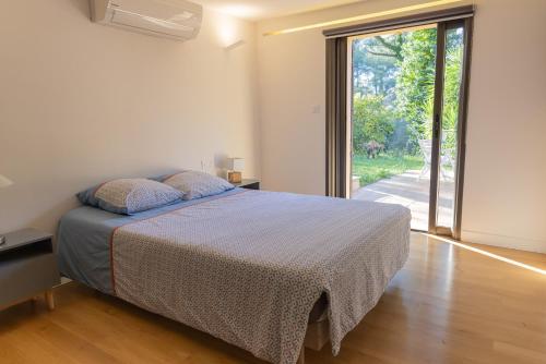 een slaapkamer met een bed en een groot raam bij Évasion et Confort Aubagne in Aubagne
