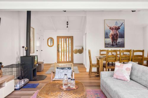a living room with a couch and a table at Bawley Point Beach House - renovated beach escape in Bawley Point