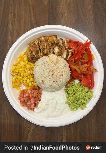a plate of food with rice and vegetables on a table at Hotel K K Casa Near New Delhi Railway Station & Connaught place in New Delhi