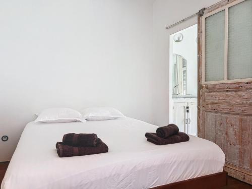 une chambre avec un lit blanc avec deux serviettes dessus dans l'établissement Loft au coeur de Marseille - Spacieux & Unique, à La Celle-sous-Gouzon