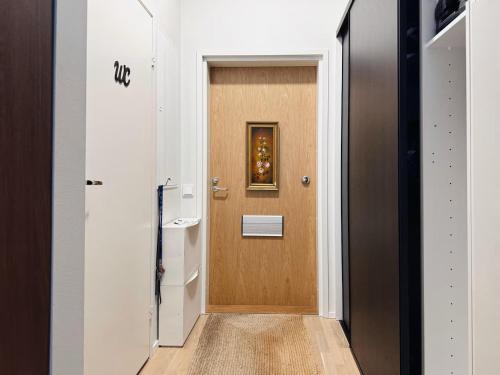 a hallway with a wooden door with a picture on it at Double Sofa Bed in a Stunningly Tall Shared Studio in Helsinki