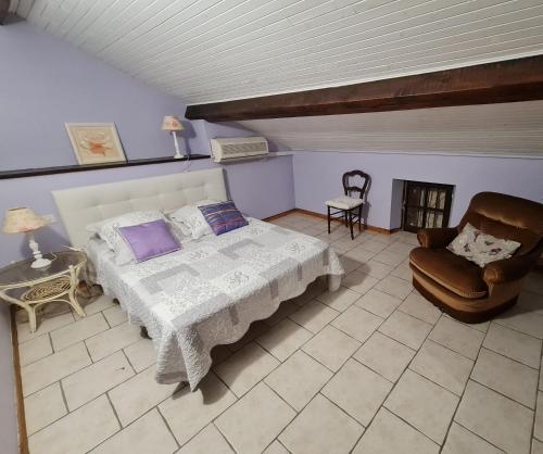 un dormitorio con una cama y una silla en Gîte de Mandarou, en Castelsagrat