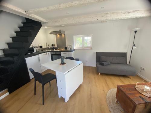 een woonkamer met een keuken en een trap bij La Petite Maison in Moyrazès