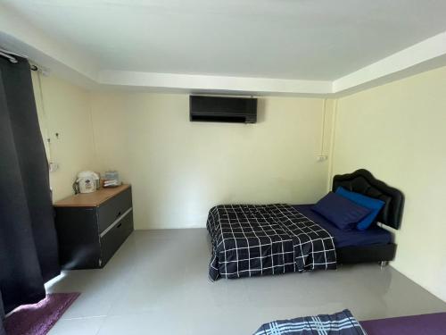 a small bedroom with a bed and a dresser at บ้านมาดาม เขาใหญ่ in Ban Chek