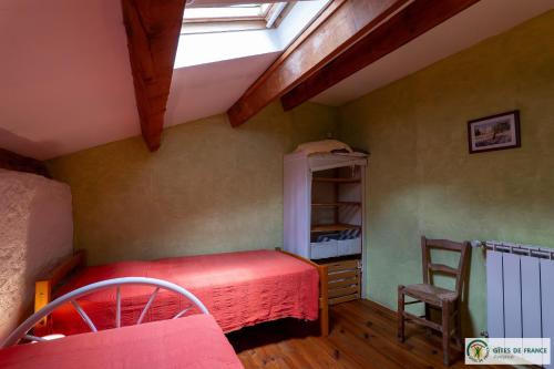 une chambre avec un lit et une lucarne dans l'établissement Le Gîte de Saint Izaire, à Broquiès