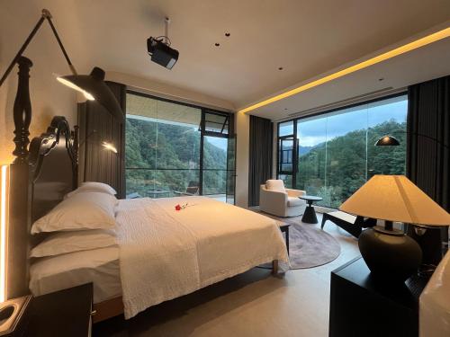 a bedroom with a bed and a large window at Nature Eco Designer Hotel in Zhangjiajie