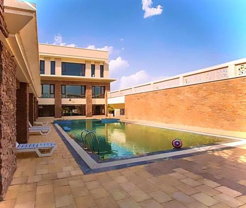 ein Schwimmbad vor einem Gebäude in der Unterkunft Apartment Balcony Private Peaceful Parking in Ajmer