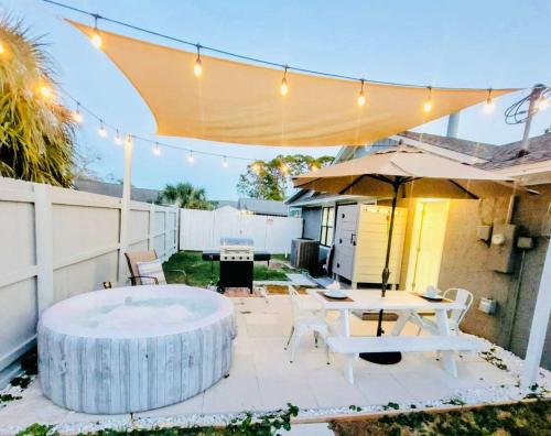 パナマ・シティ・ビーチにあるStunning 4BD Jacuzzi - 4 Min To Beach Panama Cityのパティオ(テーブル、傘付)