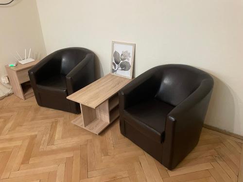 two black chairs and a table in a room at Apartament Eric in Craiova