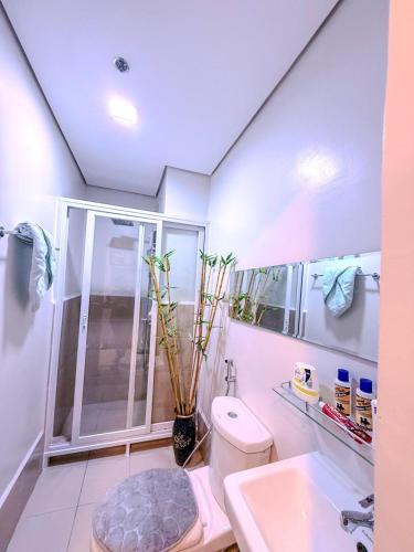 a bathroom with a shower and a toilet and a sink at Unwind with Peace at Cheer Residences SM Marilao-Philippine Arena in Marilao