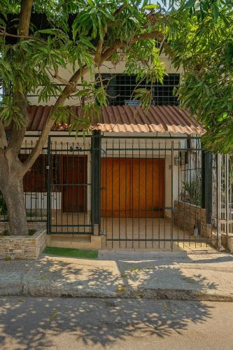 a gate in front of a building with a tree at Casa ALCATRAZ in Cartagena de Indias