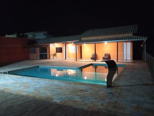 una piscina frente a una casa por la noche en Pousada Vale Canastra, en São João Batista do Glória