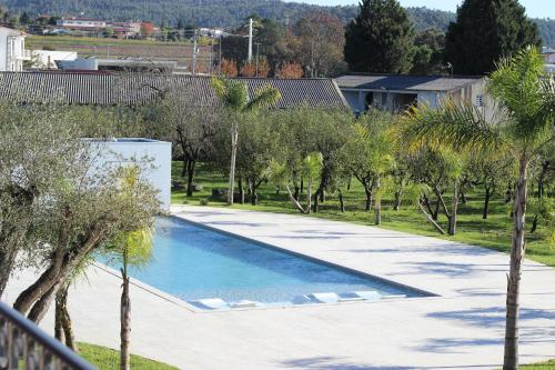 a swimming pool in a yard with trees at Quinta Solar das Fontes in Várzea