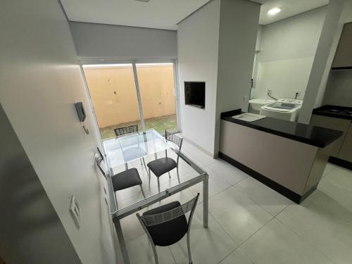 a bathroom with a glass table with chairs and a sink at Apartamento com jardim e ar condicionado na sala e quartos na Av Blumenau in Sorriso