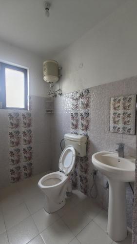 a bathroom with a toilet and a sink at Mcleodganj diaries Guesthouse in Dharamshala