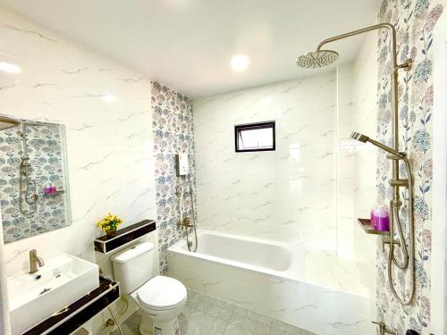 a bathroom with a tub and a toilet and a sink at Bonus Pool Villa Chiang Mai in Chiang Mai