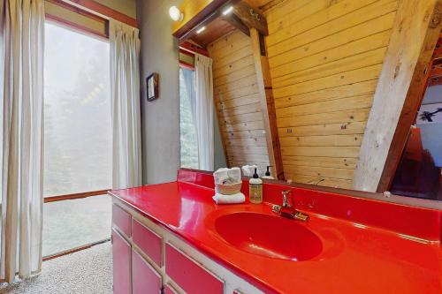 ein Badezimmer mit einem roten Waschbecken und einem Spiegel in der Unterkunft Retro Family Gathering Home in Tahoe Donner in Truckee