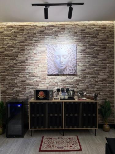 Una pared de ladrillos con una pintura de una cara en ella en مدن هاوس ودخـول ذاتي, en Hail