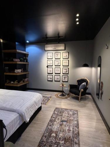 un dormitorio con una cama y una silla en مدن هاوس ودخـول ذاتي, en Hail