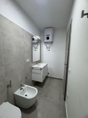een witte badkamer met een wastafel en een toilet bij Civico17room in Cirò Marina