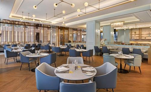 un restaurante con mesas y sillas y un bar en Golden Tulip Kin-Oasis Kinshasa, en Kinshasa