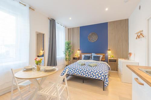 a bedroom with a bed and a table and a kitchen at Kazkle Etablissement in Boulogne-sur-Mer
