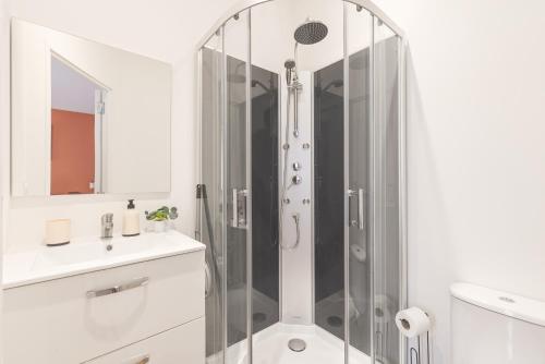a white bathroom with a shower and a sink at Kazkle Etablissement in Boulogne-sur-Mer