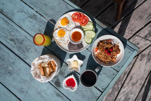 a table with plates of food and drinks on it at La Posada del Sol Boutique Hotel Tulum in Tulum