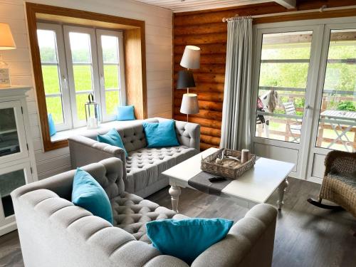 a living room with couches and blue pillows at villa kunterBUNT in Grödersby