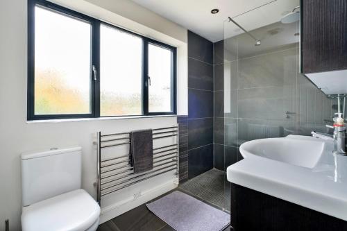 Un baño con lavabo blanco y inodoro. en Yonder, en Harley