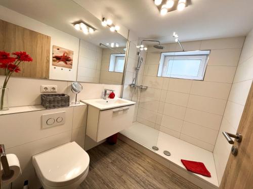 une salle de bains avec douche, toilettes et lavabo dans l'établissement villa kunterBUNT, à Grödersby