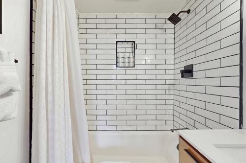 a white tiled bathroom with a shower and a sink at The Golden Moose Chalet in Grand Lake